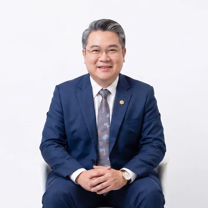 ภาพพอร์ตเทรต อาจารย์แดง พิชิตชัย ผู้เชี่ยวชาญด้านยุทธศาสตร์ไฮโล สวมชุดสูทสากลบนพื้นหลังสีขาวสะอาดตา